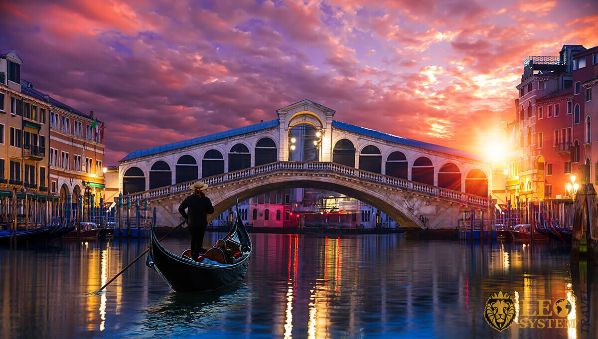 Image of a man on a boat at the time of sunset, city of Venice