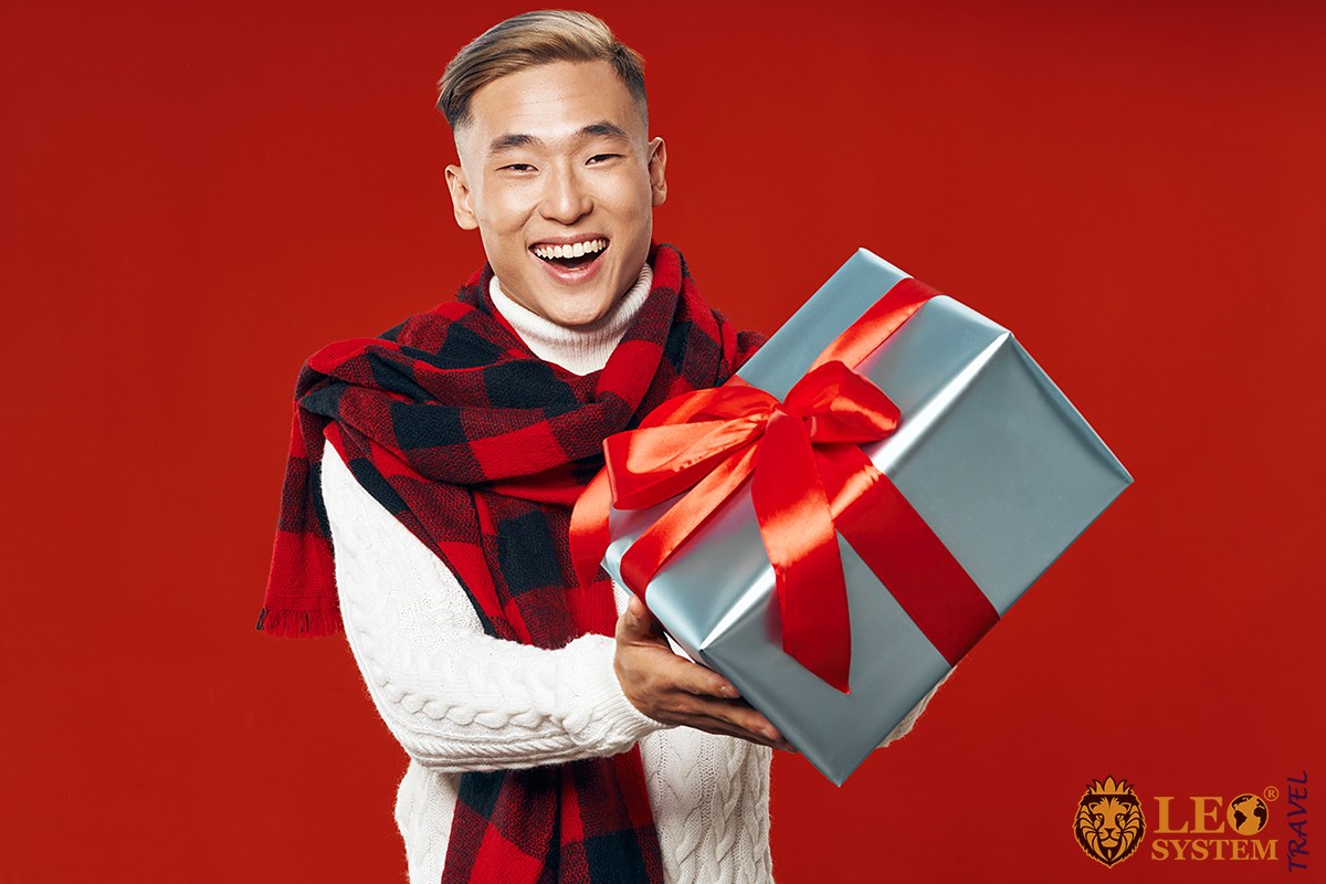 Asian man with big gift in his hands